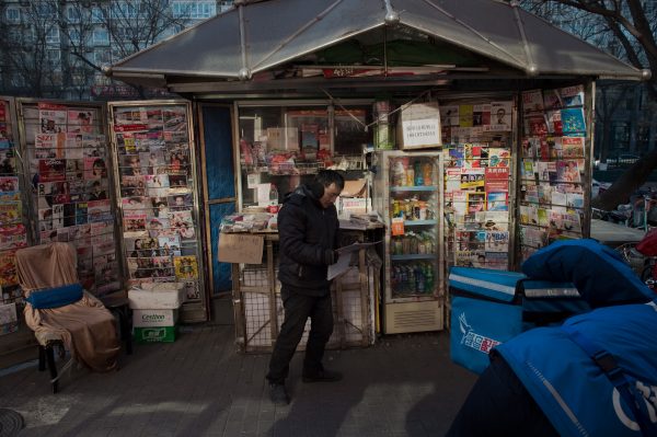 A man reads a newspaper in Beijing.