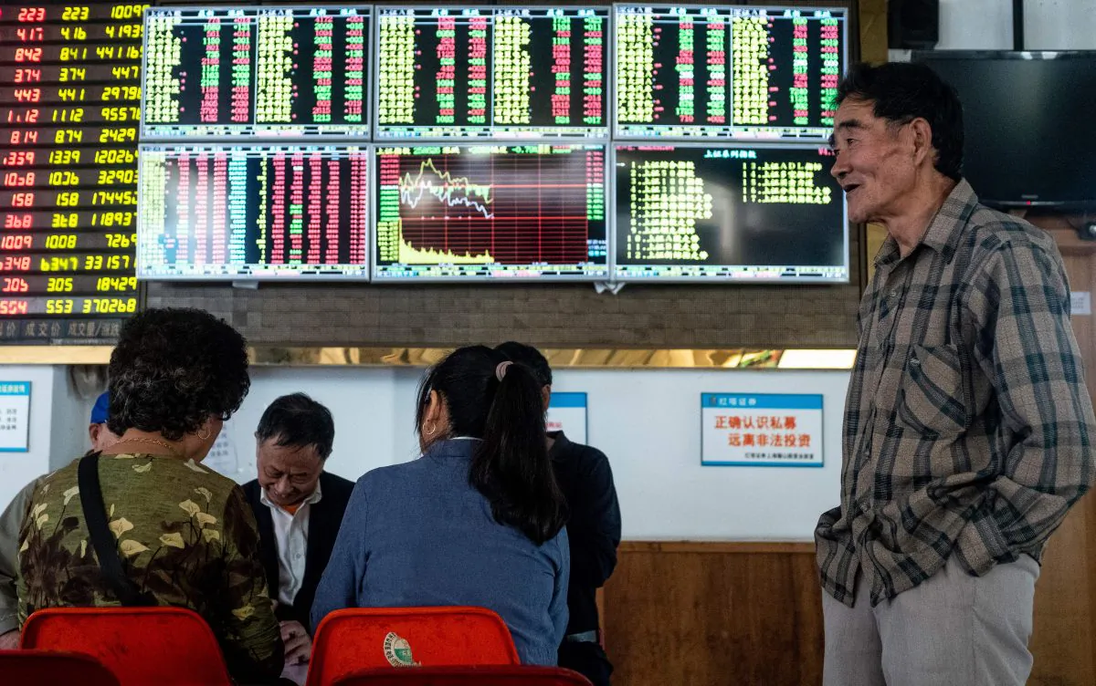 An investor looks at an electronic board showing stock information at a brokerage house in Shanghai on October 15, 2018. (Photo by JOHANNES EISELE/AFP/Getty Images)