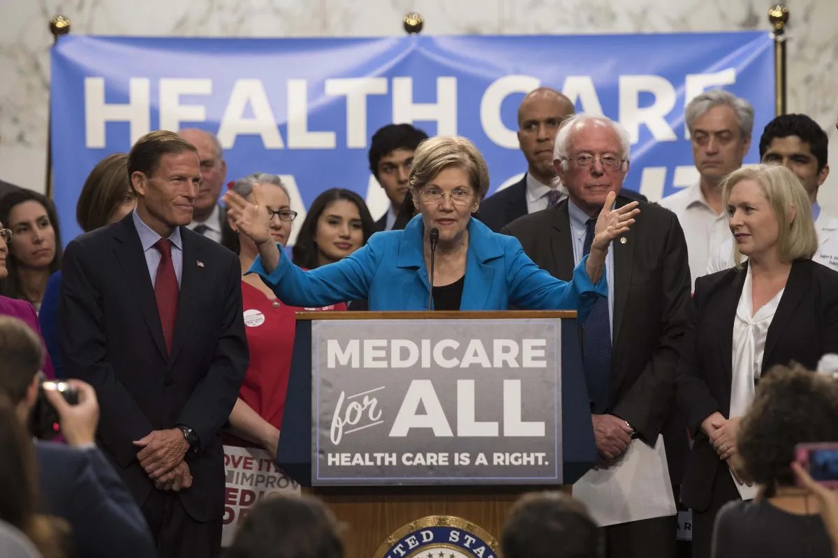 Sen. Elizabeth Warren (C), a Democrat from Massachusetts, speaks with Sen. Bernie Sanders (2nd R), an Independent from Vermont, as they discusses Medicare for All legislation on Capitol Hill in Washington, on Sept. 13, 2017. (Jim Watson/AFP/Getty Images)