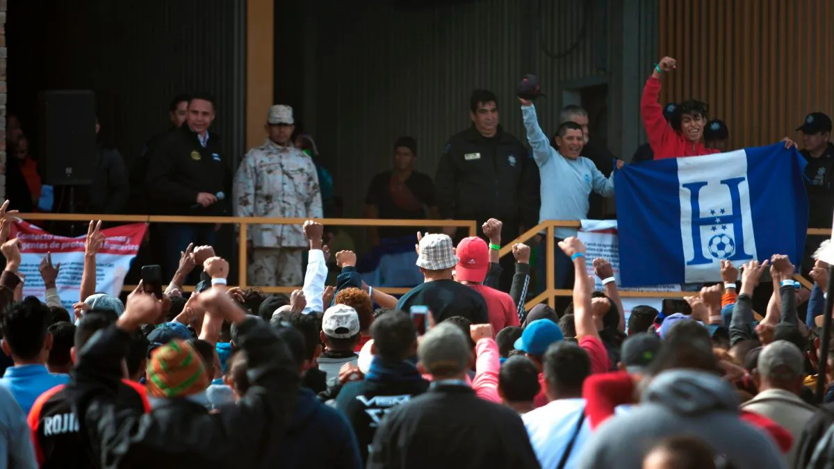 Honduran migrants show a flag after singing their national anthem at a winery used as refuge in Piedras Negras, Coahuila State, Mexico, on Feb. 7, 2019. (Julio Cesar Aguilar/AFP)