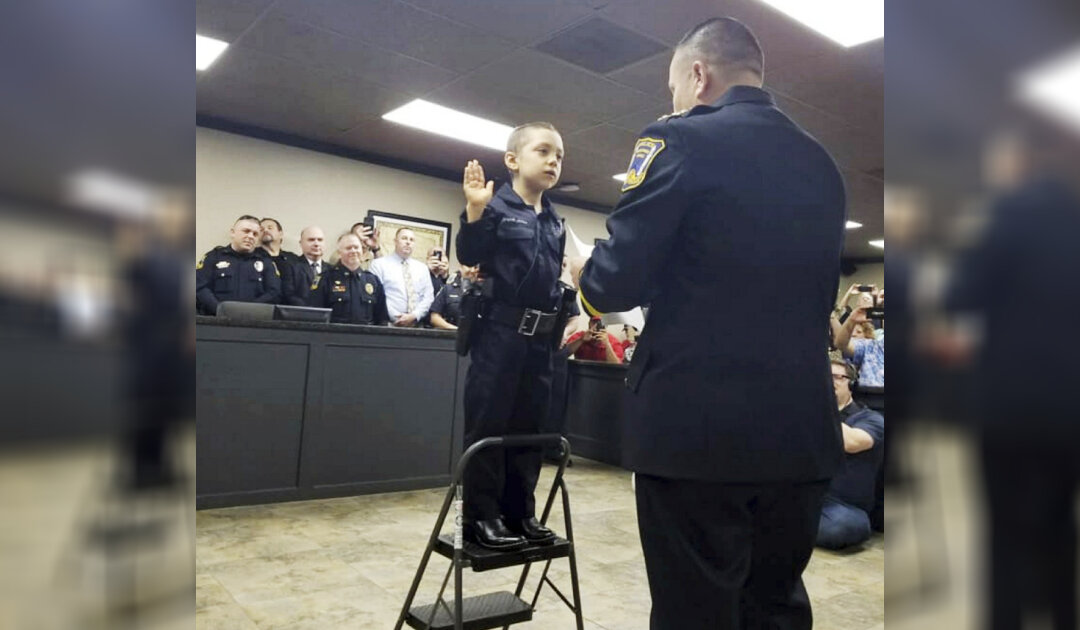 In this Feb. 7, 2019 photo provided by the Freeport Police Department, 6-year-old Abigail Arias, who is battling cancer, is sworn in as a Texas police officer by Freeport Police Chief Ray Garivey in Freeport, Texas. (Freeport Police Department via AP)
