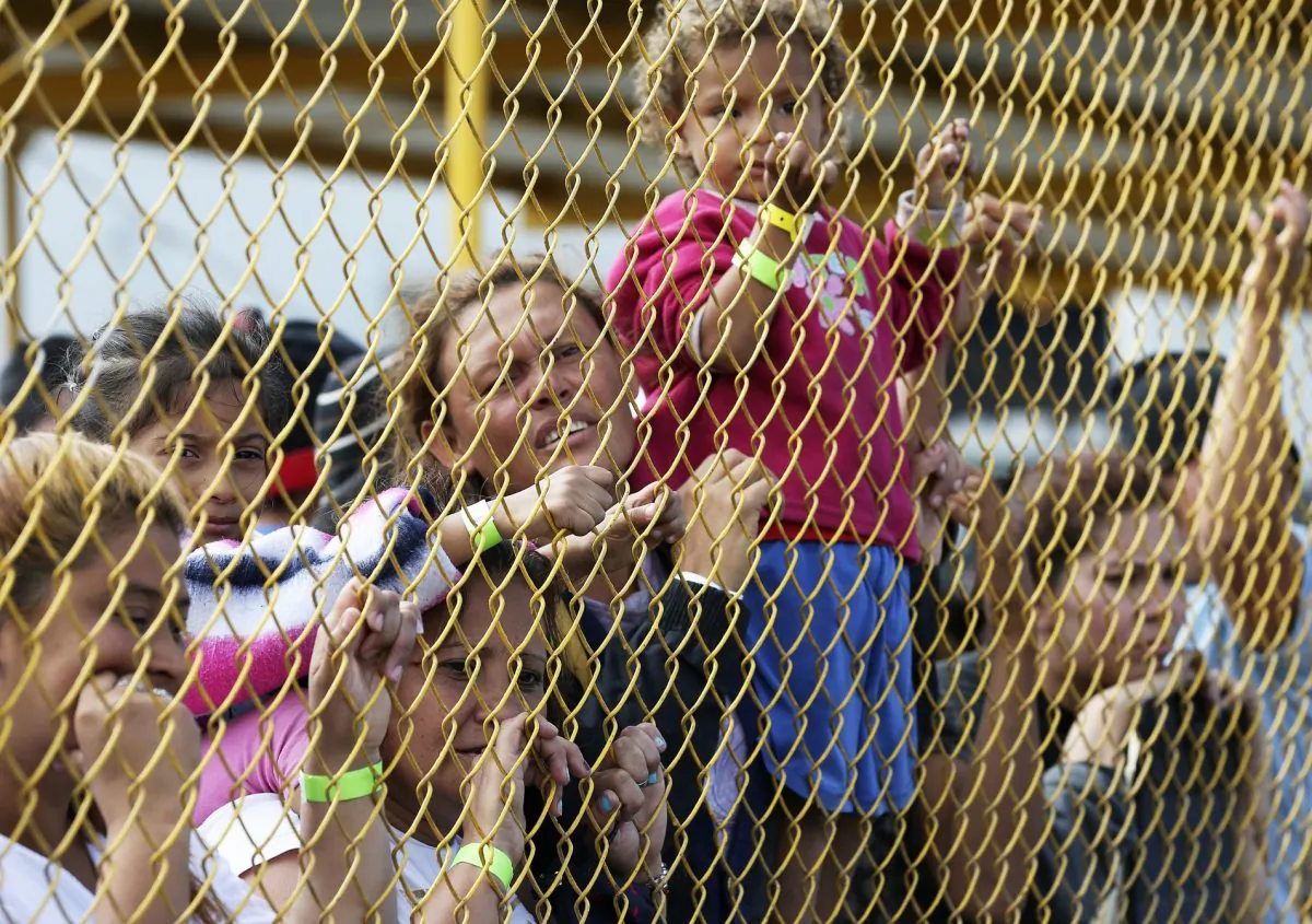 Central American immigrant families look out through the fence of a shelter in Piedras Negras, Mexico, on Feb. 5, 2019. (Jerry Lara/The San Antonio Express-News via AP)