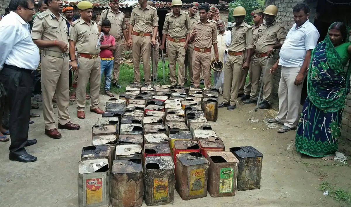 Indian police gather around containers of bootleg alcohol recovered in a raid after multiple deaths from alcohol poisoning in Azamgarh Village in Uttar Pradesh State on July 11, 2017.
(STR/AFP/Getty Images)