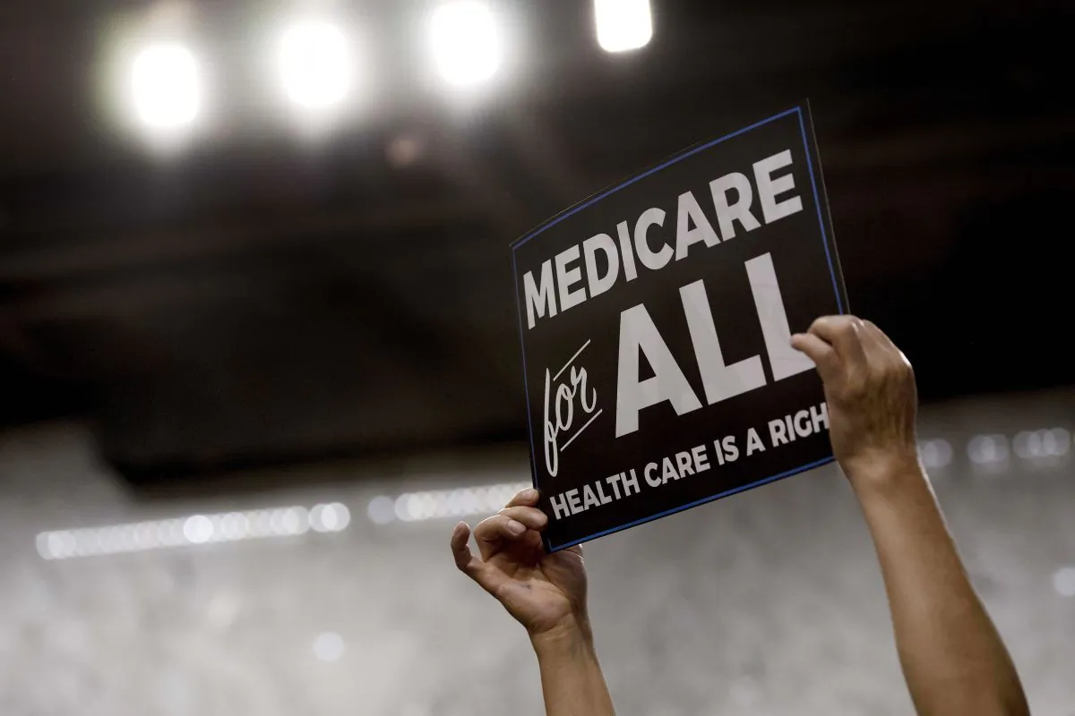 A member of the audience holds up a placard as US Sen. Bernie Sanders, (I-Vt.), discusses Medicare for All legislation on Capitol Hill in Washington on Sept. 13, 2017. JIM WATSON/AFP/Getty Images