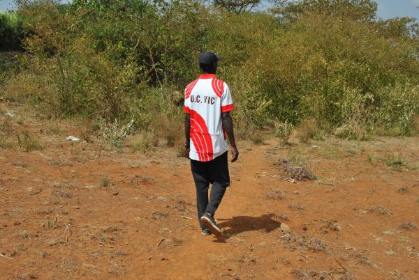man walking towards bushes