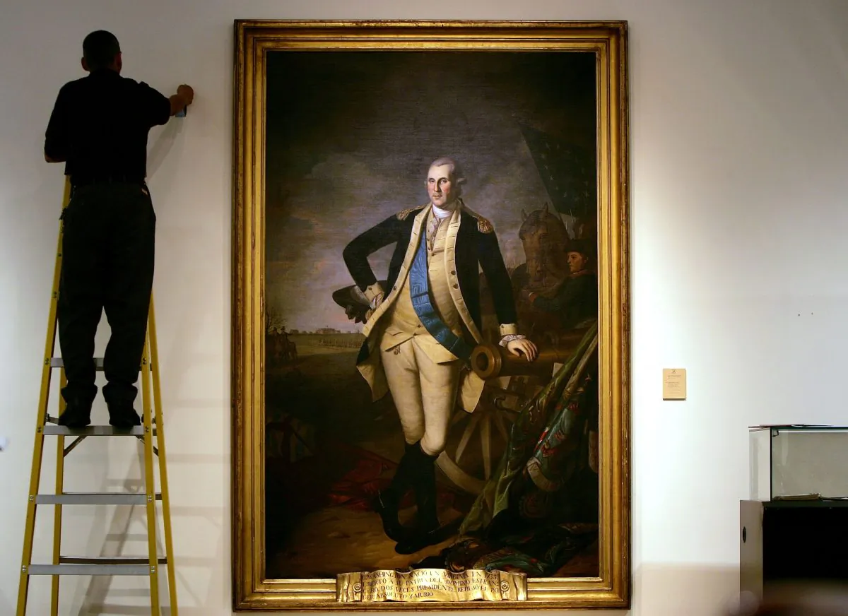 A worker uses a ladder to work near a Charles Willson Peale portrait of founding US President George Washington, shown here as a General after the Battle of Princeton, at Christie's auction house in New York on Jan. 17, 2006. (Spencer Platt/Getty Images)