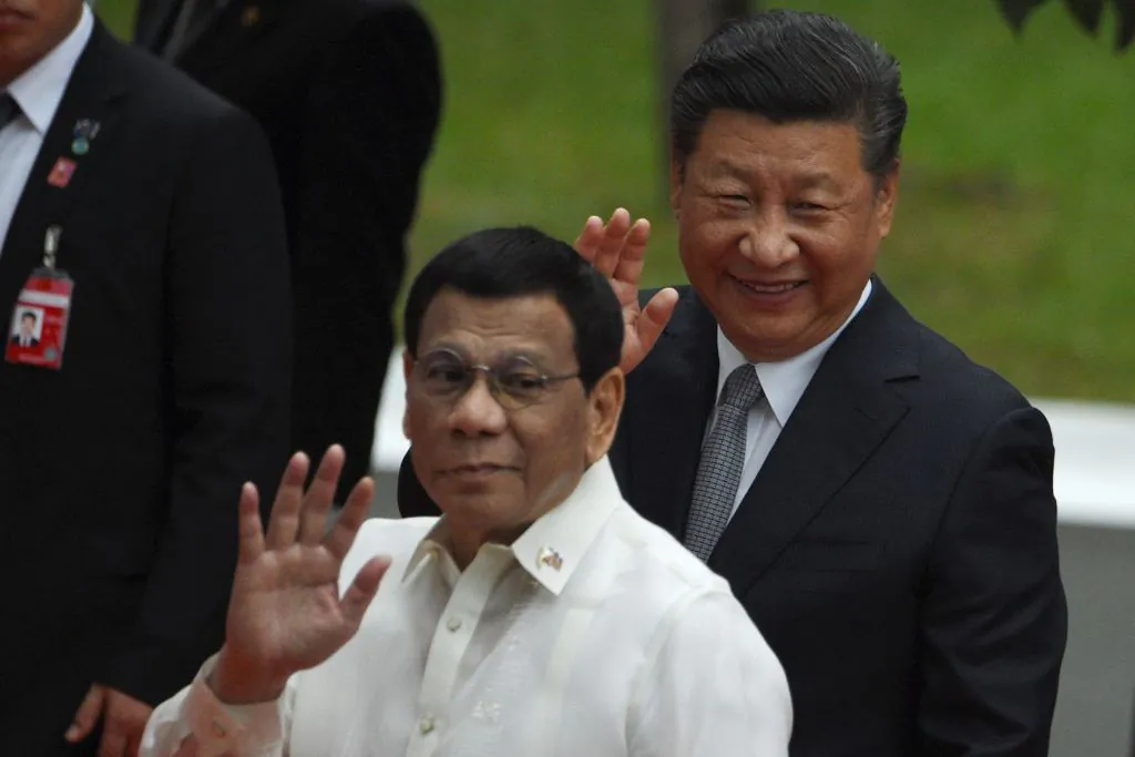 Chinese leader President Xi Jinping (R) and Philippines' President Rodrigo Duterte waves to members of the media after inspecting the honor guard during a welcoming ceremony at the Malacanang Palace in Manila on Nov. 20, 2018. (Ted Aljibe/AFP/Getty Images)