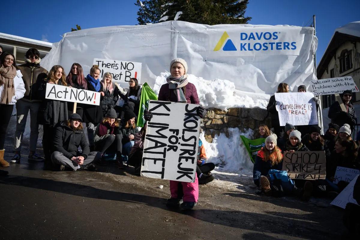 Swedish youth climate activist Greta Thunberg (C) holds a placard next to students during a "School strike for climate" held on the sidelines of the World Economic Forum (WEF) annual meeting, on January 25, 2019 in Davos, eastern Switzerland. FABRICE COFFRINI/AFP/Getty Images