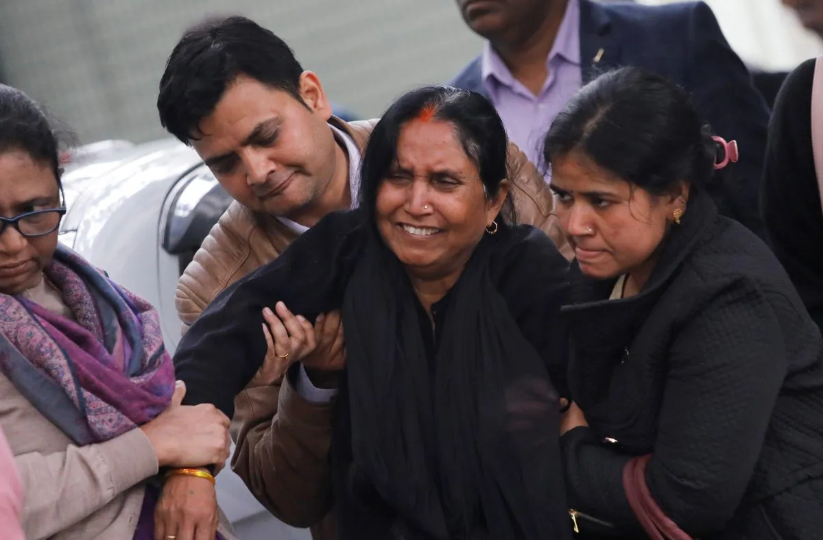 A woman cries as family members hold her while waiting outside a mortuary to receive the body of her relative, who was killed in a fire at a hotel in New Delhi, India, Feb. 12, 2019.(Anushree Fadnavis/Reuters)