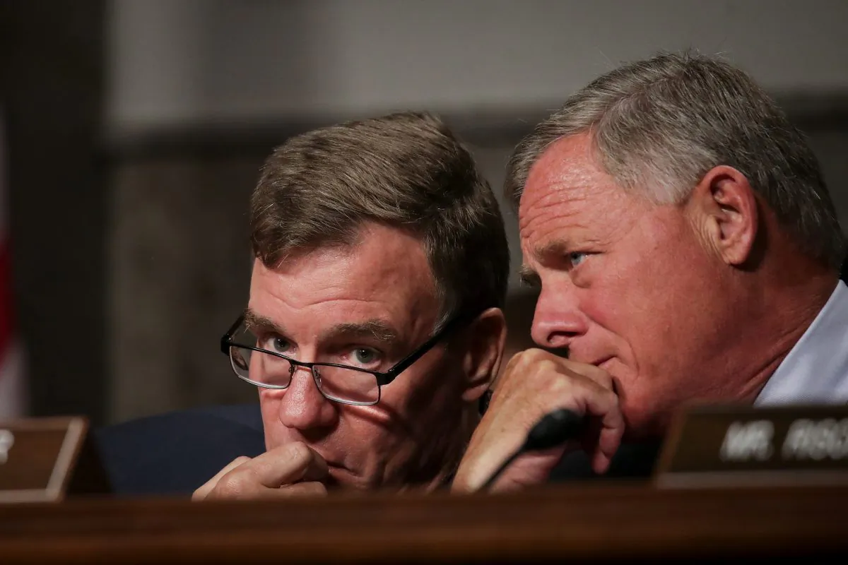 Committee ranking member Sen. Mark Warner (D-VA) (L) talks with
committee Chairman Sen. Richard Burr (R-NC) during a Senate Intelligence Committee hearing on Capitol Hill, Sept. 5, 2018. (Drew Angerer/Getty Images)