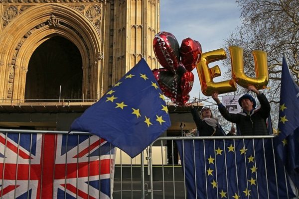 Anti-Brexit pro-EU demonstrator Steve Bray (R) holds up balloons spelling out the letters "EU"