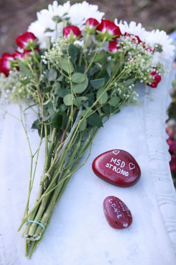 Flowers and stones are shown at a memorial outside Marjory Stoneman Douglas High School