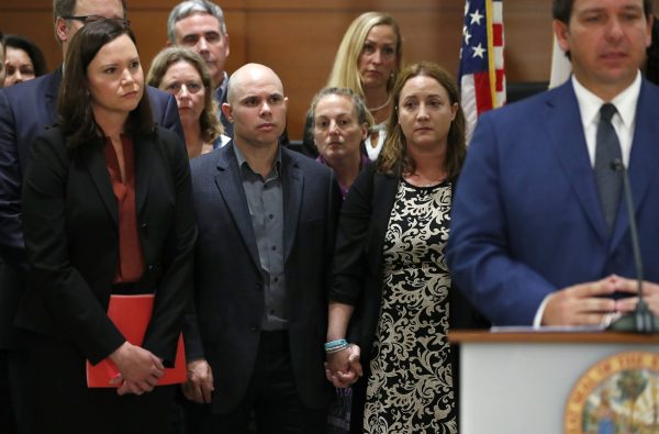 Ilan and Lori Alhadeff, center, the parents of Alyssa Alhadeff, who was killed in the Parkland, Fla., school shooting, hold hands