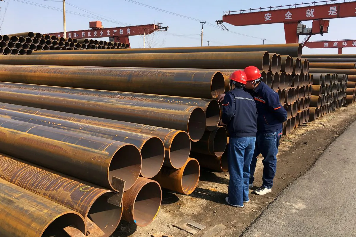 Workers inspect steel pipes at a steel mill of Hebei Huayang Steel Pipe Co Ltd in Cangzhou, Hebei Province, China on March 19, 2018. (Muyu Xu/Reuters)