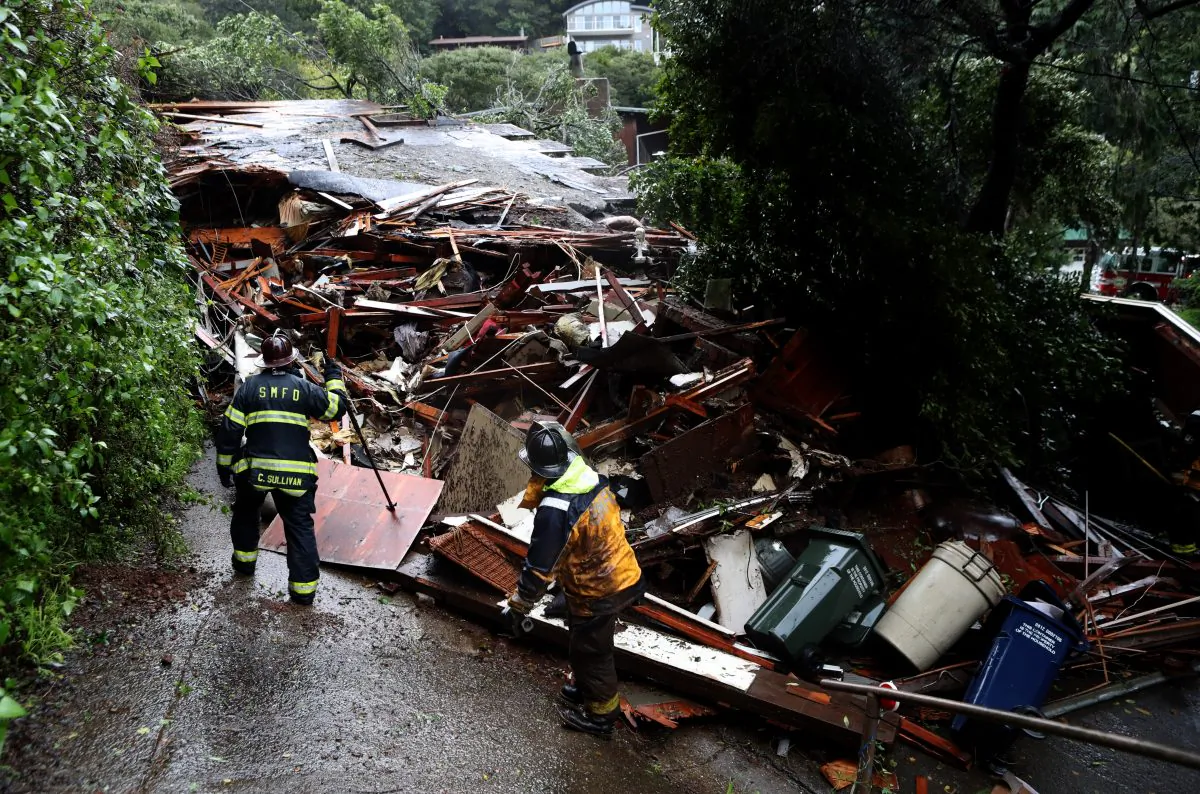Southern Marin firefighters search a home that was swept down a hill by a mudslide during a rain storm on February 14, 2019 in Sausalito, California. 50 homes in the town of Sausalito were evacuated after a mudslide struck homes and sent at least one sliding 75 yards down a hill. No injuries were reported. (Photo by Justin Sullivan/Getty Images)