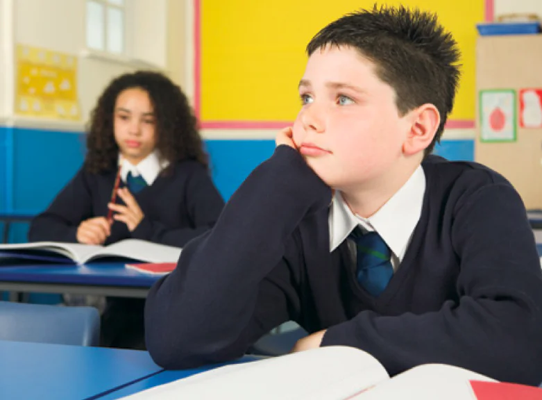 A boy sits in a classroom in school. (Cultura Motion/Shutterstock)