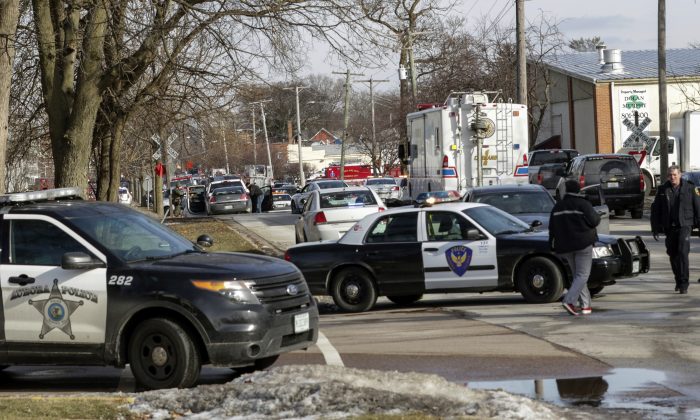 Law enforcement personnel gather near the scene of a shooting at an industrial park in Aurora, Ill., on Feb. 15, 2019. (Bev Horne/Daily Herald via AP)