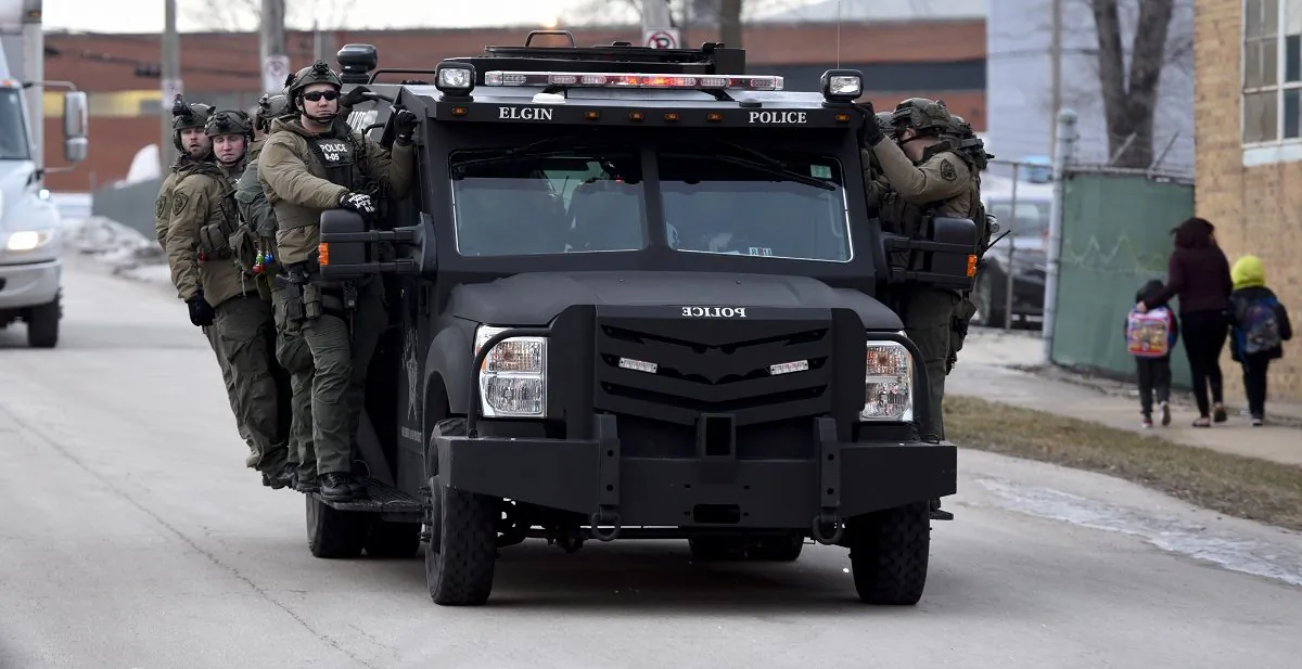 Police officers ride on a vehicle near the site of a shooting at a manufacturing plant in Aurora, Ill., that police said left several people dead, and several police officers wounded, on Feb. 15, 2019. (Matt Marton/AP Photo)