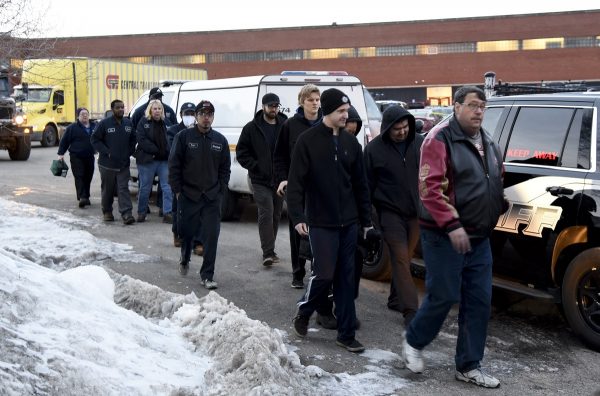 Employees are escorted from the scene of a shooting at a manufacturing plant