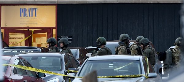 Law enforcement officers gather outside the Henry Pratt Co. manufacturing plant