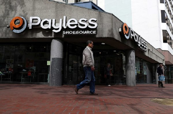 A pedestrian walks by a Payless Shoe Source store in San Francisco