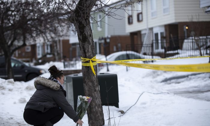 Local resident Jennifer Fuller places flowers at the scene outside of a house where a young girl was found dead in Brampton, Ont. on Feb. 15, 2019. (The Canadian Press/Andrew Ryan)