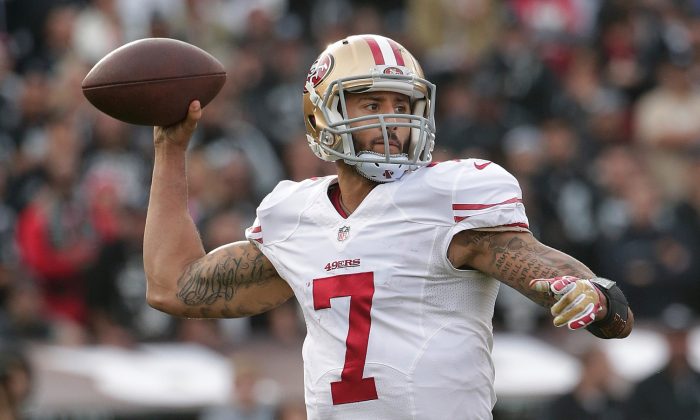 File photo showing now former San Francisco 49ers quarterback Colin Kaepernick passing against the Oakland Raiders during the second quarter of an NFL football game in Oakland, Calif., Sunday, Dec. 7, 2014. (AP Photo/Marcio Jose Sanchez)