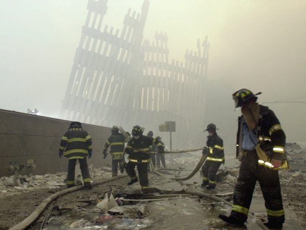 New York City firefighters work amid debris on Cortlandt St. after the terrorist attacks on Sept. 11, 2001