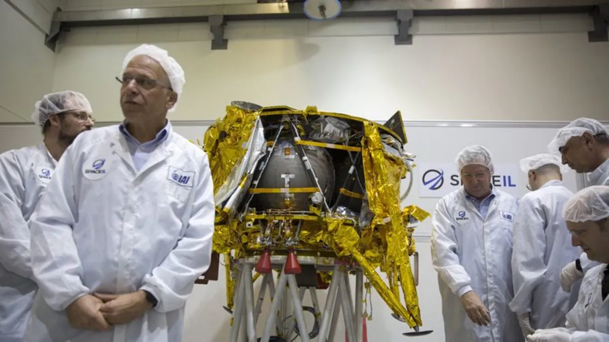 Technicians stand next to the SpaceIL lunar module, an unmanned spacecraft, is on display in a special "clean room" where the spacecraft is being developed, during a press tour of their facility near Tel Aviv, Israel. SpaceIL and state-owned Israel Aerospace Industries told a news conference that the landing craft will take off from Florida, to its weekslong voyage to the moon. (AP Photo/Ariel Schalit, File)