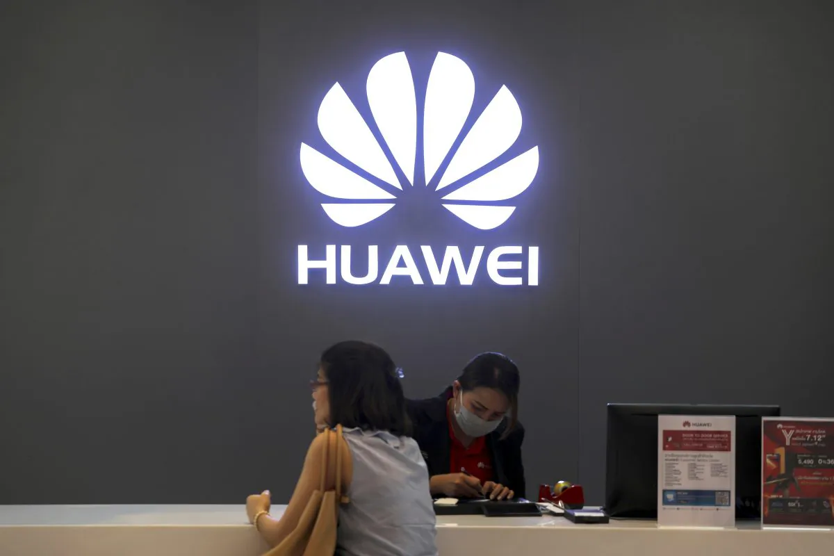 A woman sits next to a salesperson at a Huawei shop in Bangkok, Thailand on Jan. 30. (Athit Perawongmetha/Reuters)