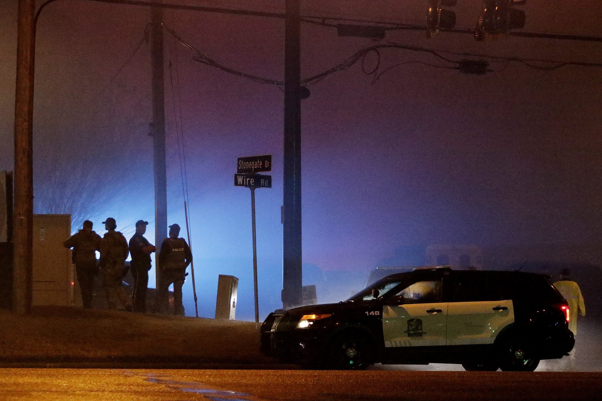 Law enforcement officers stand at the corner