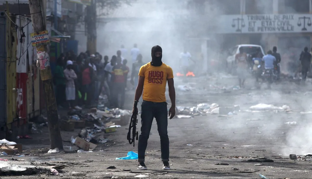 A man holds a weapon next to burning barricades during anti-government protests in Port-au-Prince, Haiti, Feb. 17, 2019. (Ivan Alvarado/Reuters)