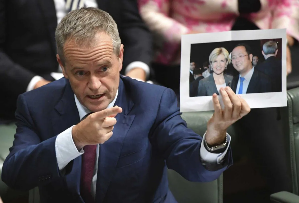 Former Australian Opposition Leader Bill Shorten holds a photograph of Australian Foreign Minister Julie Bishop with Chinese businessman Huang Xiangmo during House of Representatives Question Time at Parliament House in Canberra on June 14, 2017. (Lukas Coch/AAP Image)