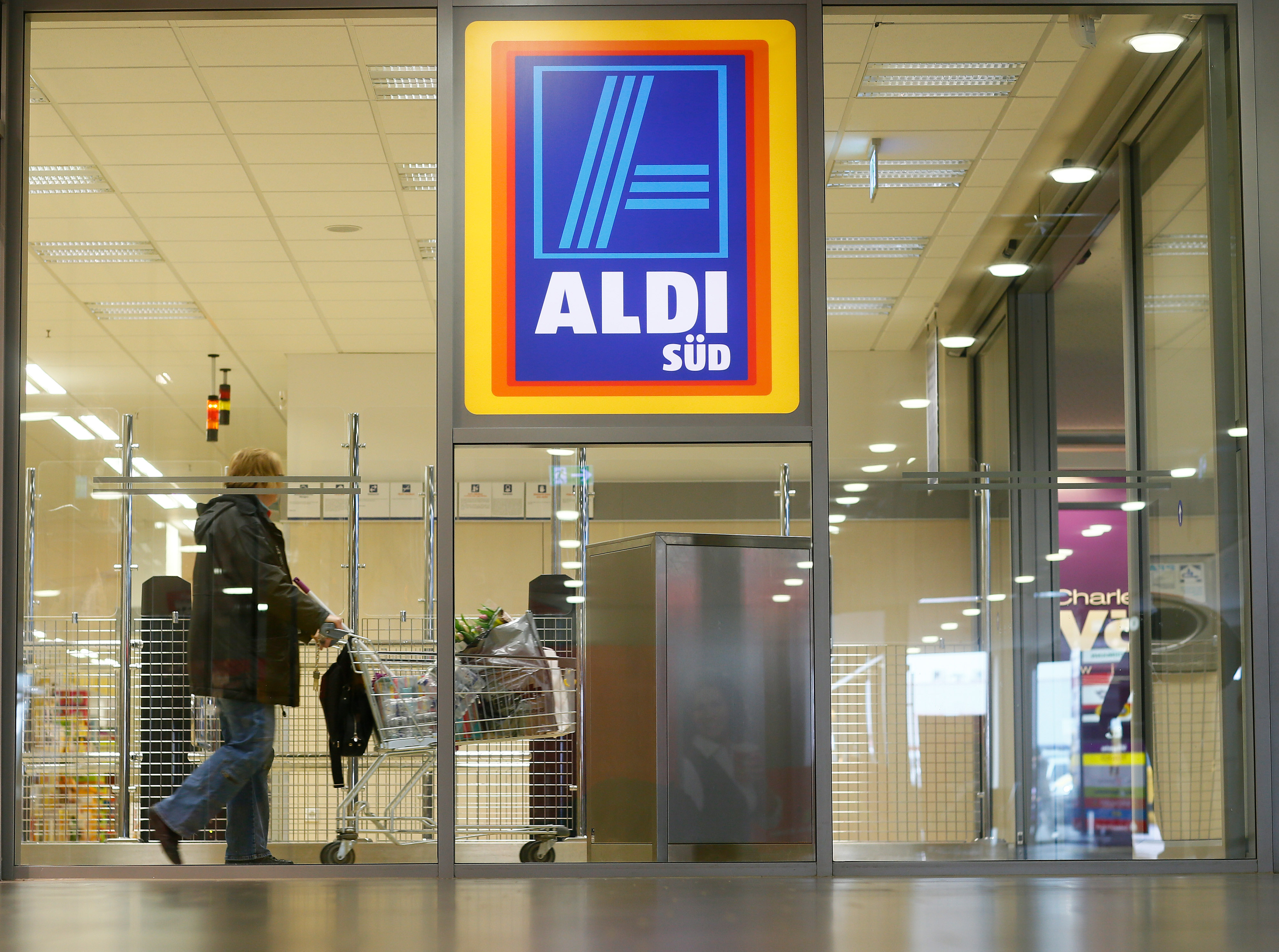 A shopper pushes a shopping cart in an Aldi