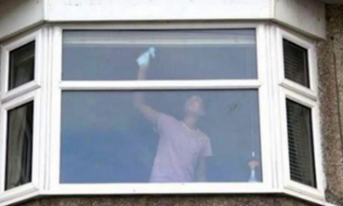 Police in the United Kingdom shared a photo of a woman cleaning a window, but they say there is something wrong with it. (Avon and Somerset Police)