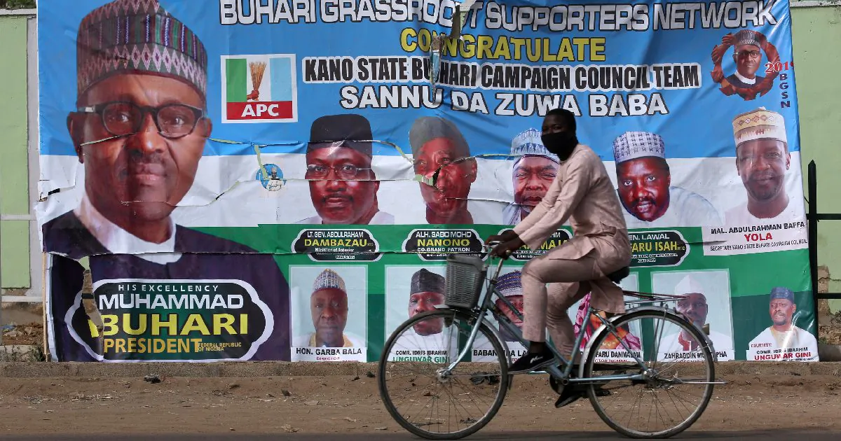 A cyclist drives pasts a campaign poster for President Muhammadu Buhari in a street after the postponement of the presidential election in Kano, Nigeria Feb. 17, 2019. (Luc Gnago/Reuters)