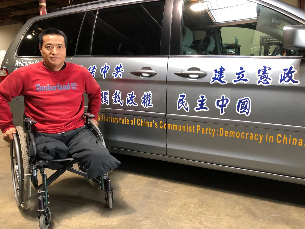 Fang Zheng in his home on Feb. 20, 2019. TThe Chinese words painted on the van say: End the Chinese Communist Party regime, and build new constitutional democracy in China. (Courtesy Fang Zheng)