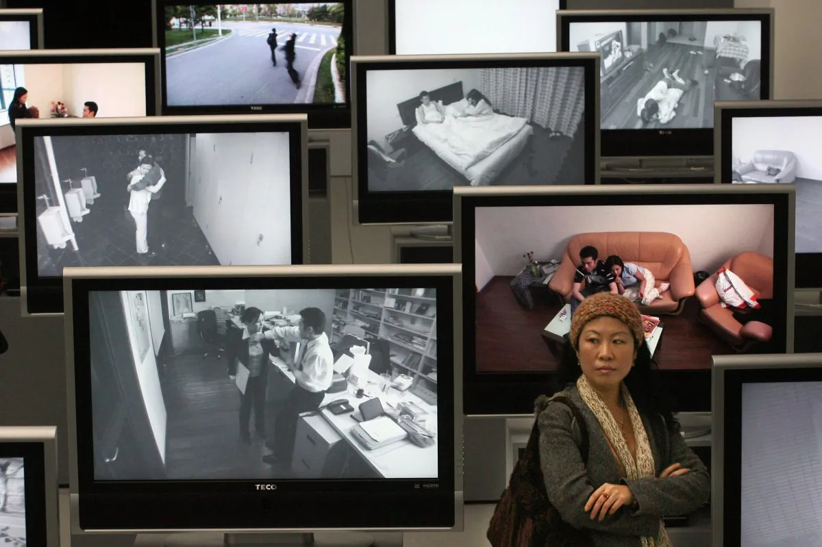 A Chinese woman stands next to videos showing domestic violence and marriage breakdowns at an exhibition in Shanghai, on March 15, 2007. (Mark Ralston/AFP/Getty Images)