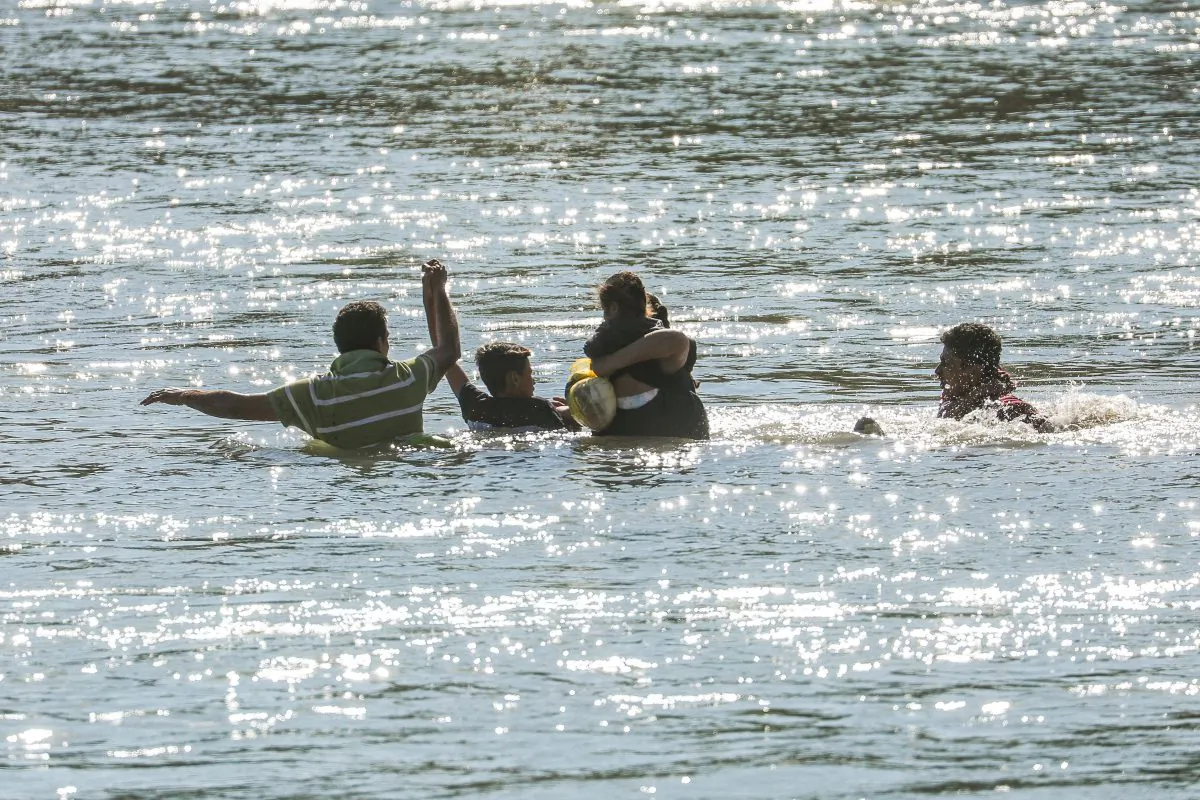 Illegal border crossers are rescued by agents on a U.S. Customs and Border Protection boat as they get stuck halfway across the Rio Grande from Mexico into Eagle Pass, Texas, on Feb. 16, 2019. (Charlotte Cuthbertson/The Epoch Times)