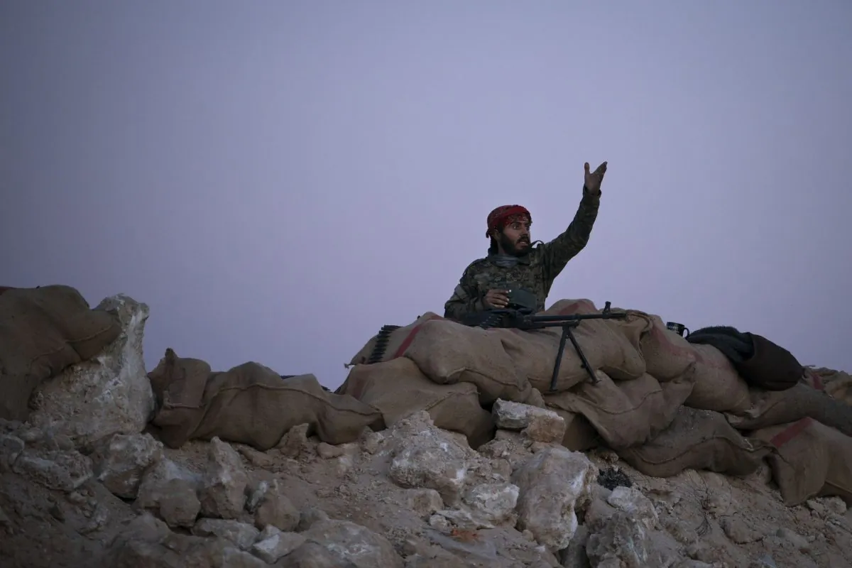 A U.S.-backed Syrian Democratic Forces (SDF) fighter reacts as an airstrike hits territory still held by ISIS militants in the desert outside Baghouz, Syria, on Feb. 19, 2019. (Felipe Dana/AP Photo)