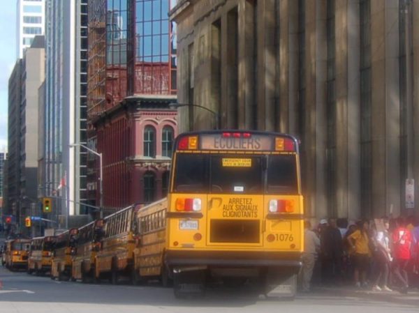 A long line of school buses parked near Parliament Hill.