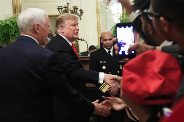 President Donald Trump with Vice President Mike Pence shakes hands with Surgeon General Jerome Adams