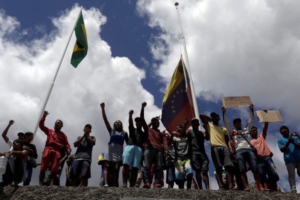 People waiting to cross to Venezuela gesture at the border