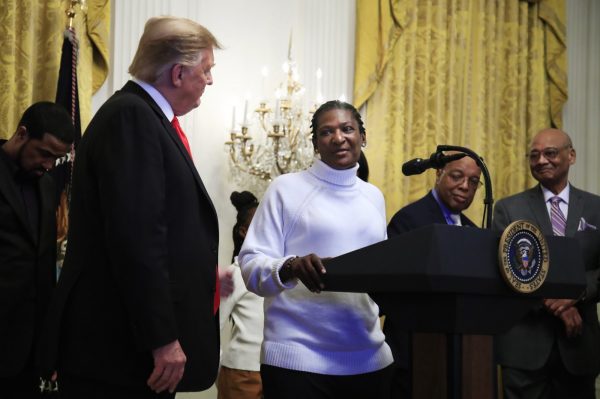 President Donald Trump listens to Catherine Toney speak during a National African American History Month reception