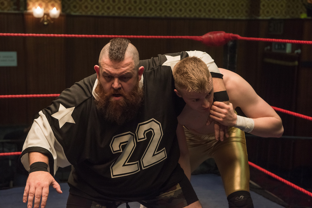 Dad and son wrestle in the ring