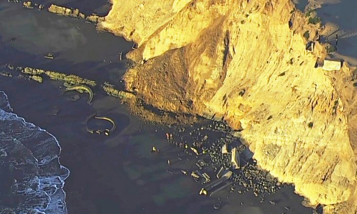 Firefighters searching for a person who was thought to be buried by a landslide near a San Francisco beach, on  Feb. 22, 2019. (KGO-TV via AP)
