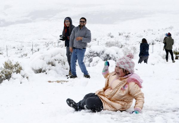 Valentina Gonzalez, 7, laughs after falling during a snowball fight