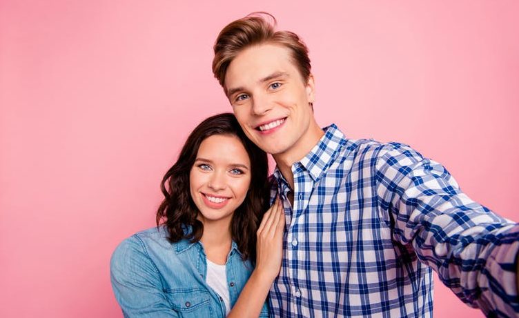 A young couple posing for a selfie could accidentally complicate their relationship by adding in new layers of approval seeking.
(RomanSamborskyi/Shutterstock)