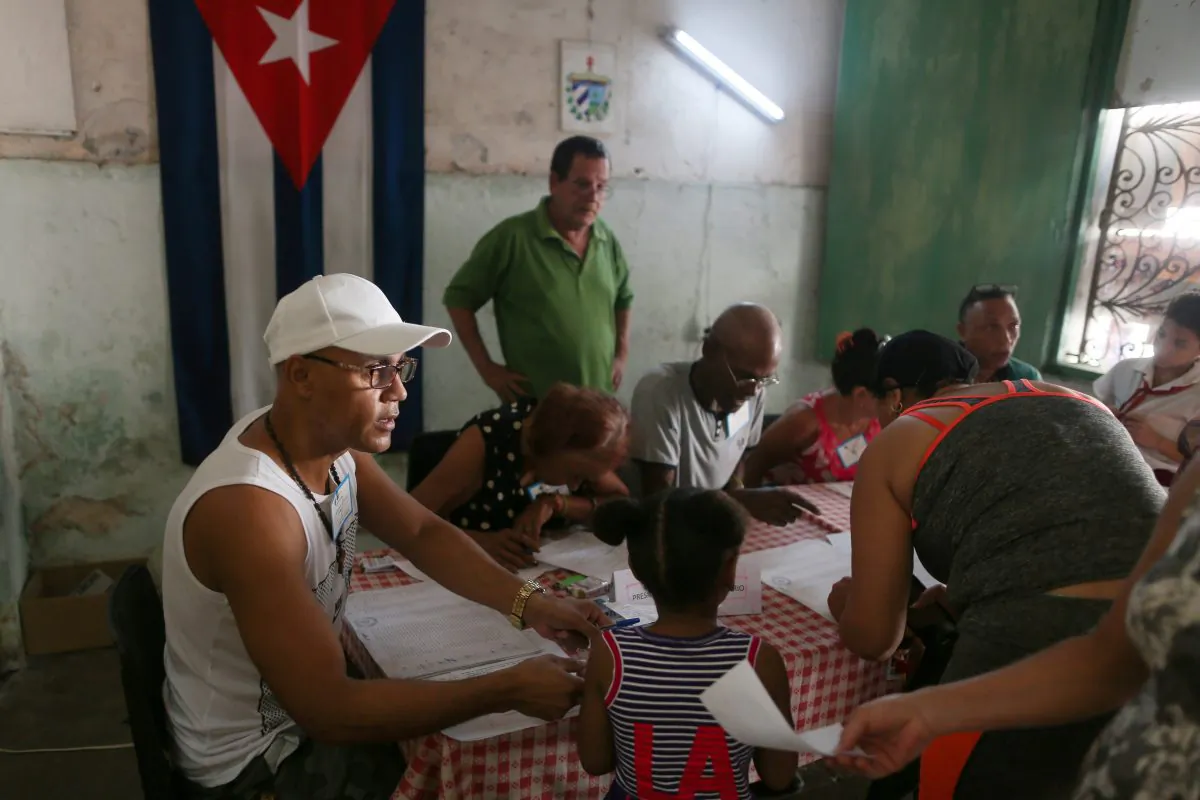 Election officials check the documents of a voter at a polling station during a constitutional referendum in Havana, Cuba, Feb. 24, 2019. (Fernando Medina/Reuters)