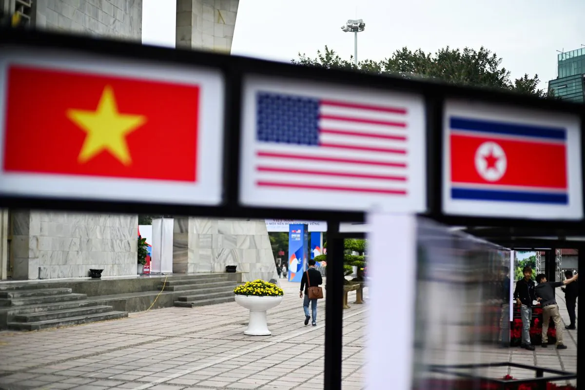 People walk past pictures of Vietnam, US and North Korean flags in Hanoi on Feb. 25, 2019, ahead of the second US-North Korea summit. (JEWEL SAMAD/AFP/Getty Images)